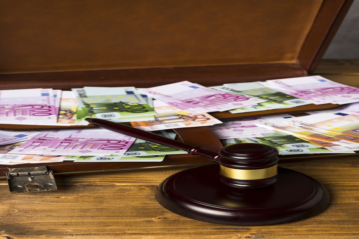 İcra takibi konseptli masa üstünde banka paraları,hakim tokmağı ve evraklar-borç tahsilatı ve hukuki takip süreci
